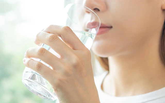 女性が薬を飲む写真