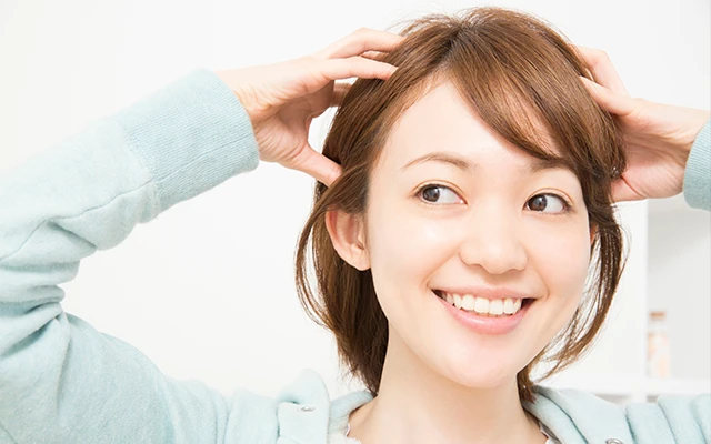 女性が髪を触っている画像